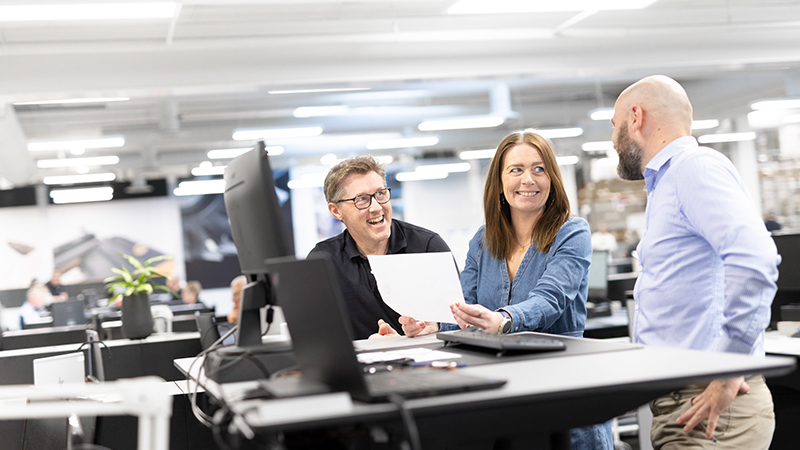 3 people standing in an office environment