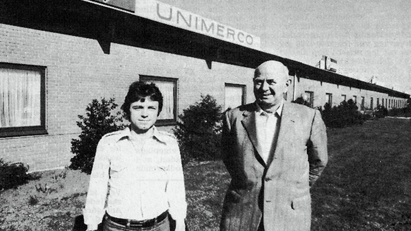 Dos CEO anteriores, Kenneth Iversen y Hans Foxby, de pie delante del edificio Unimerco en Sunds en 1976