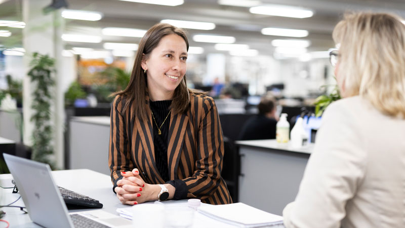 2 colleagues having a conversation at an office desk