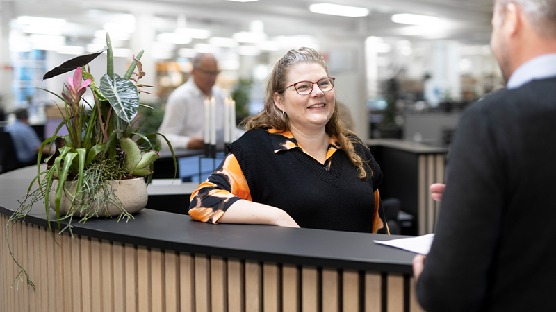 Una persona de recepción da la bienvenida a la empresa a un cliente