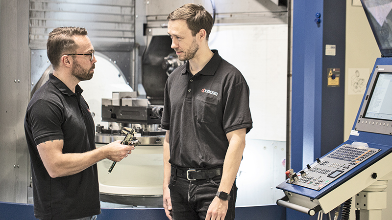 2 technicians standing in front of a CNC machine